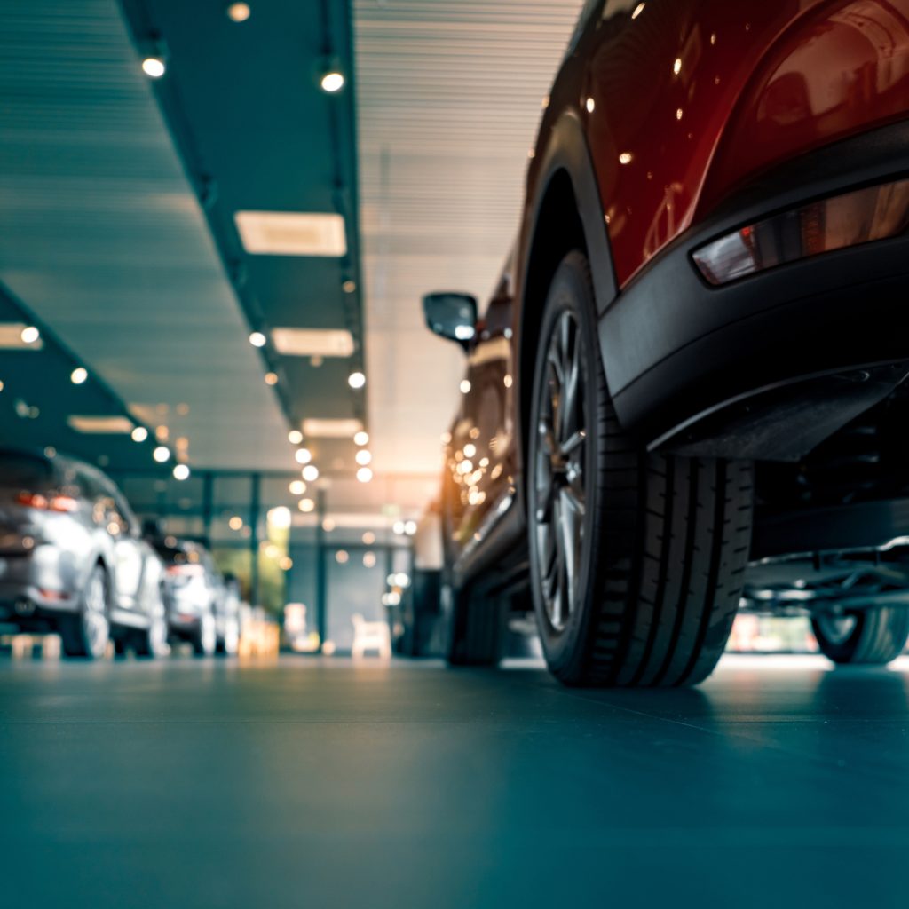 Rearview of parked cars Car dealership office. New car parked in modern showroom. Automobile leasing and insurance concept.
